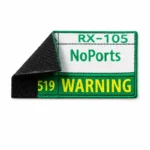 A close-up of an embroidered patch labeled "RX-105 NoPorts 519 WARNING," with a partially peeled black hook and loop backing on the left side. The patch features green and yellow thread colors with the text clearly visible.
