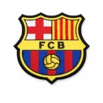 An embroidered FC Barcelona (FCB) shield-shaped patch featuring the red cross, Catalan stripes, blue and red vertical stripes, and a yellow football emblem, finished with a bold black and yellow border.