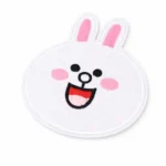 A white embroidered bunny face patch with pink ears and cheeks, black eyes, and a smiling mouth, neatly finished with laser-cut edges for a clean, smooth outline.