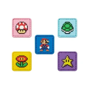 A set of six square PVC patches featuring retro pixel-art game icons, including a red mushroom, green shell, Mario character, fire flower, yellow star, and green turtle shell, each on a colorful background.