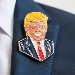 A detailed enamel pin depicting a stylized portrait of Donald Trump wearing a navy suit and red tie, attached to a dark blazer lapel.