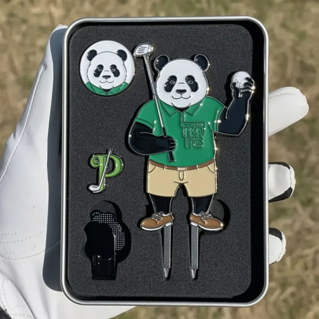 A colorful panda golfer pin set with green shirt details, including a divot tool and logo markers, arranged in a case on a golf course.
