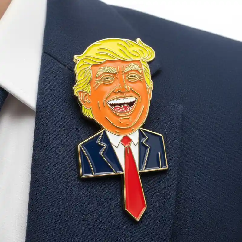 Custom soft enamel lapel pin with a detailed cartoon face, featuring blue enamel skin and yellow hair on a navy blazer.