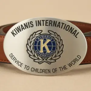 An oval metal belt buckle engraved with Kiwanis International and the motto service to the children of the world.