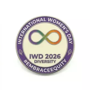 Round enamel pin for International Women’s Day 2026 featuring a colorful infinity symbol and the text “IWD 2026 Diversity #EmbraceEquity”.