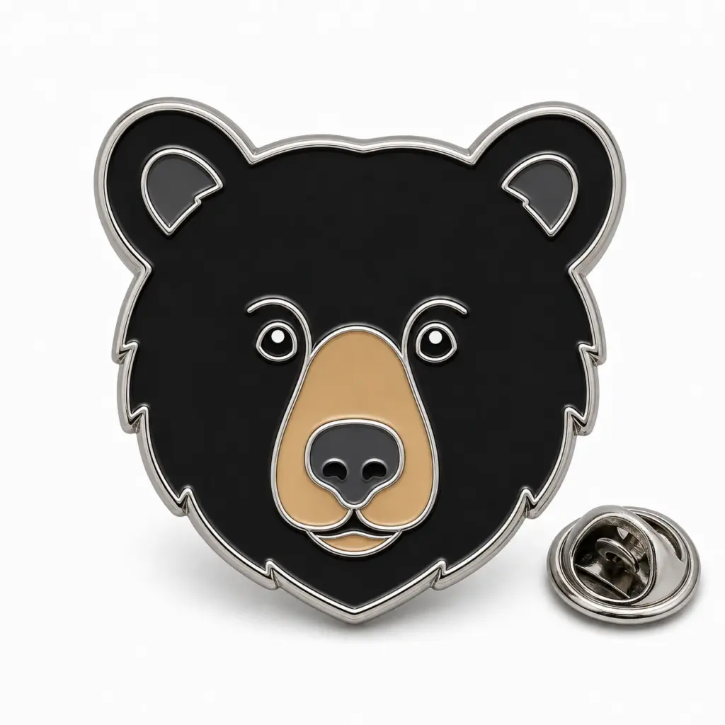 Épingle personnalisée en émail souple avec tête d'ours noir, contours argentés et pochette de papillon sur fond blanc.