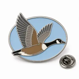 Custom flying Canada goose soft enamel pin with silver outlines and butterfly clutch on a white background.