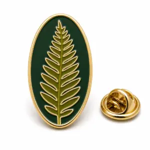 Long fern leaf enamel pin with dark green flat enamel, gold metal outline, and butterfly clutch on white background.