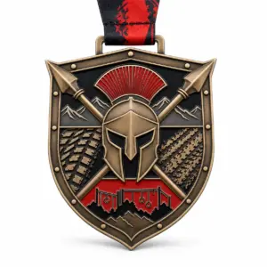 Shield spear Spartan race medal soft enamel medal with raised bronze metal dividers, red and tan enamel panels, crossed spear details, and ribbon loop on white.