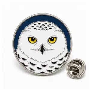 Custom snowy owl head soft enamel pin with gold raised outlines, white feather cells, and butterfly clutch on a clean studio background.