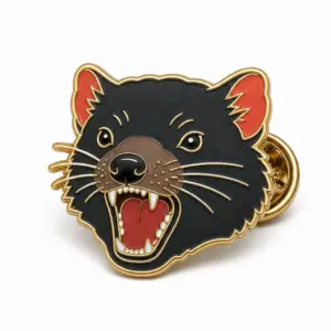 Custom tasmanian devil face soft enamel pin with raised metal outlines and butterfly clutch on a white background.