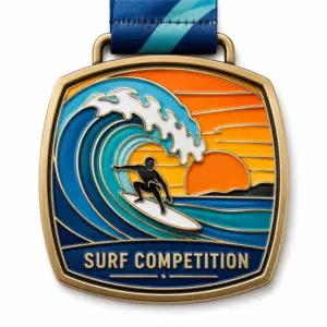 Golden sunset wave Surf Competition Medal soft enamel medal with raised antique gold outlines, surfer silhouette, curling blue ocean wave, orange sunset sky, navy title panel, ribbon loop, and blue striped neck ribbon on a white background.