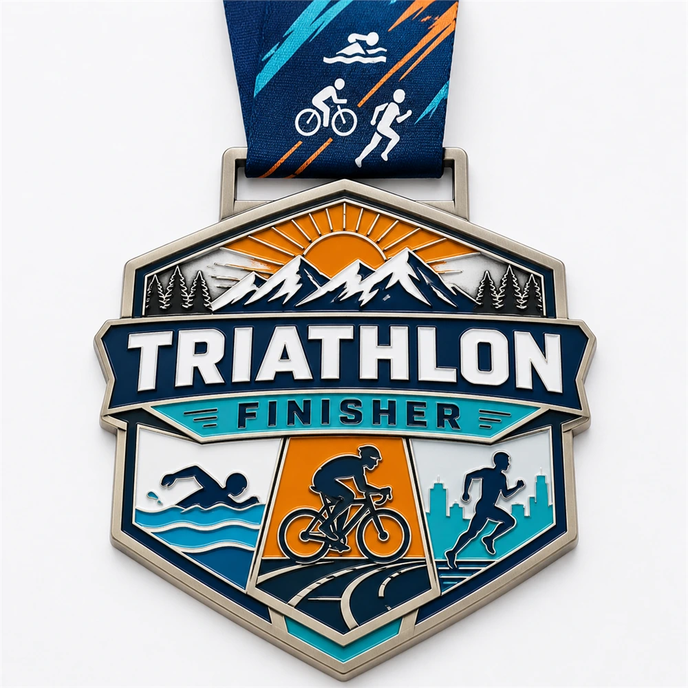 Mountain sunrise Triathlon Finisher Medal soft enamel medal with raised silver outlines, swim bike run panels, orange sunrise, snowy mountains, city runner scene, ribbon loop, and triathlon neck ribbon on a white background.