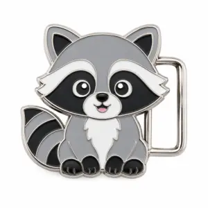 Cute raccoon enamel belt buckle with gray, black and white cartoon wildlife design, polished metal outline, side belt loop, striped tail, and white background.