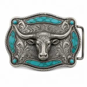 Turquoise longhorn western belt buckle with raised silver bull head, engraved floral scrollwork, turquoise stone inlay panels, rope border, and white background.