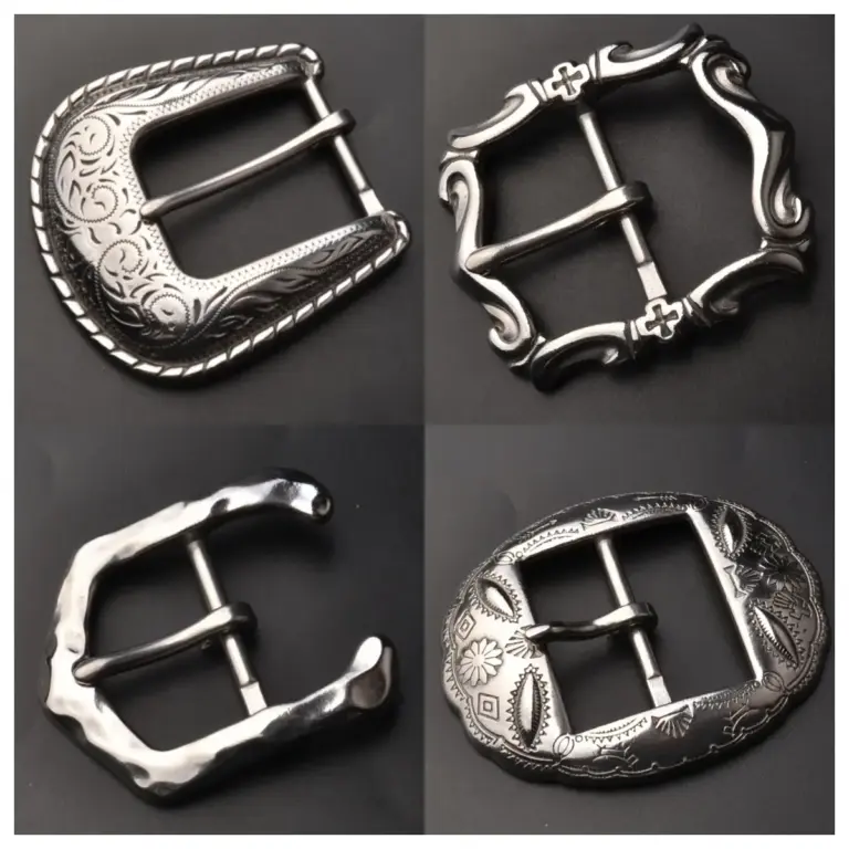 A set of four stainless steel belt buckles displayed on a dark background, featuring different polished silver finishes, engraved patterns, and decorative buckle frame styles.