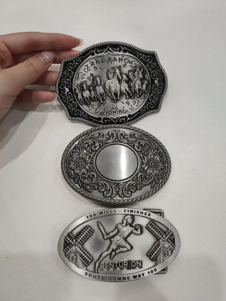 A collection of vintage style belt buckles featuring antique metal finishes, engraved patterns, embossed artwork, and western-inspired decorative designs.